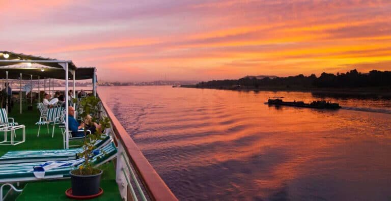 travelers-enjoying-the-sunset-while-sailing-between-luxor-and-aswan Travelers enjoying a sunset while sailing the Nile between Luxor and Aswan.
