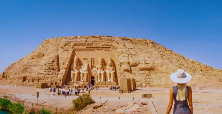 Woman with long blonde hair admires the Abu Simbel temple in Aswan, Egypt.