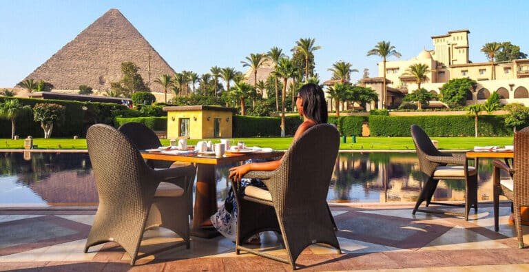 A-stunning-photo-of-a-girl-sitting-in-a-hotel-overlooking-the-pyramids